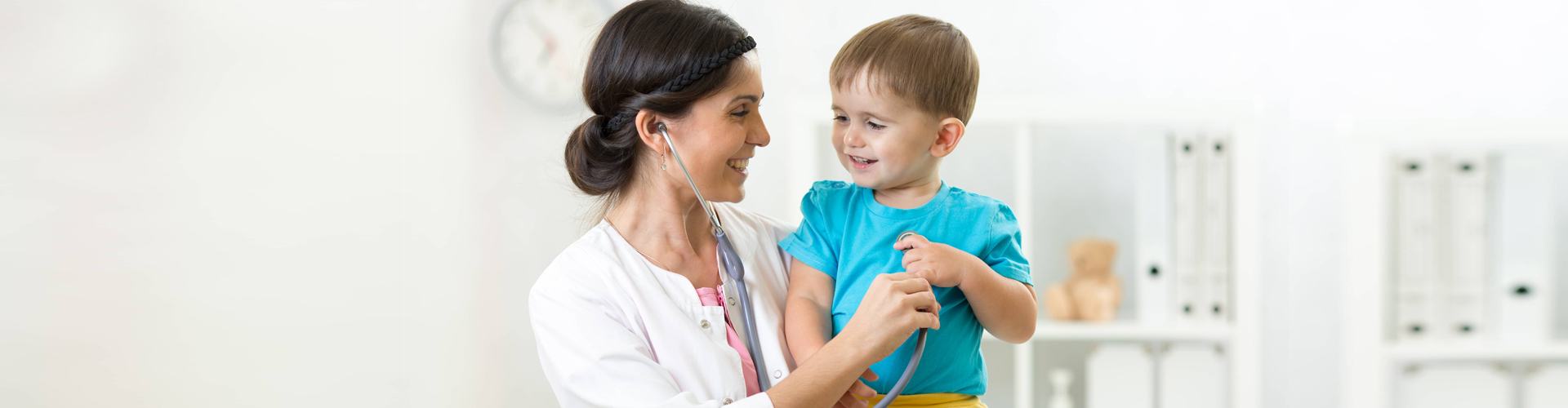a pediatrician and a child smiling at each other